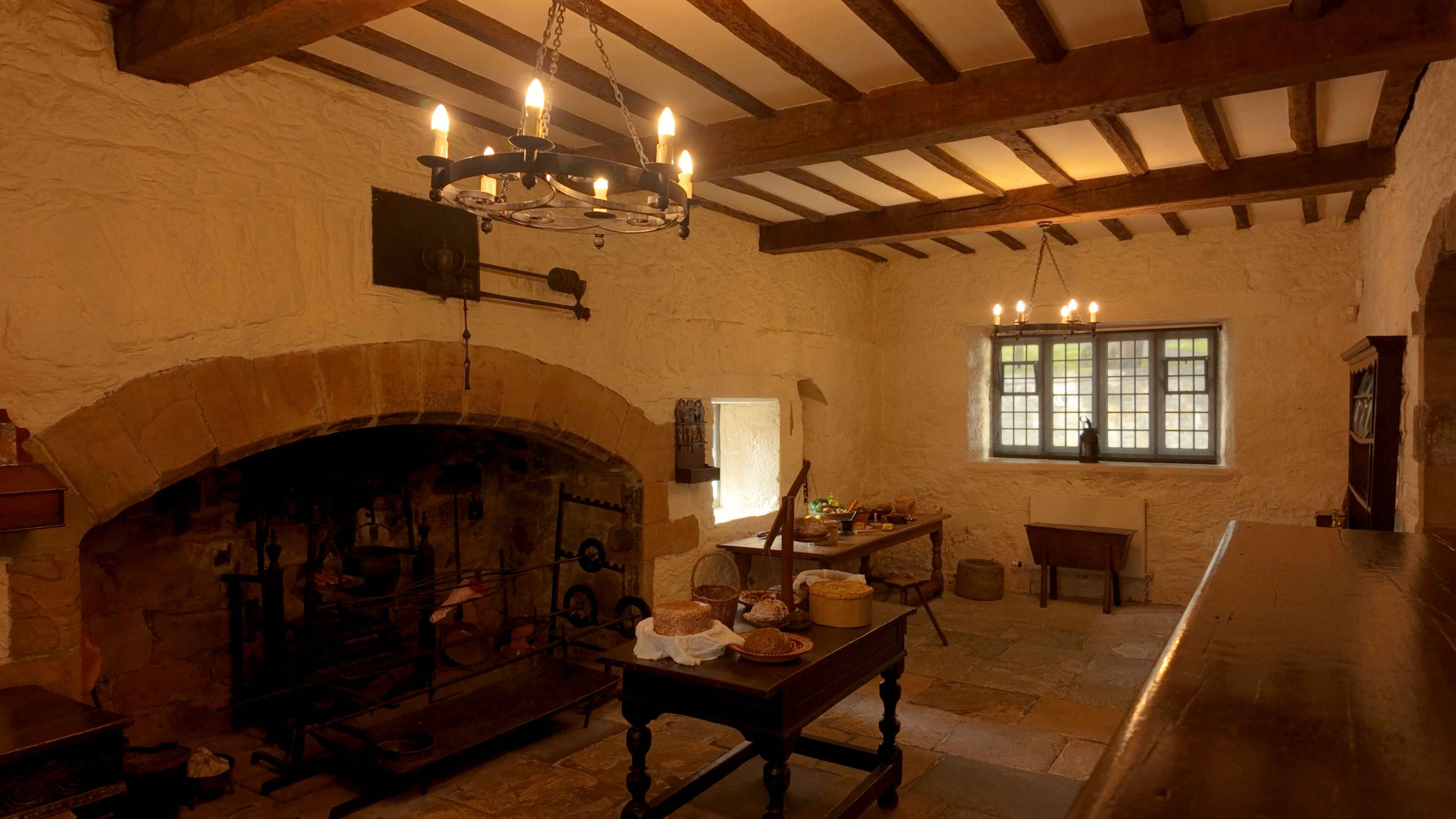 An old fashioned stone kitchen fitted with its original furnishings and a window at the back