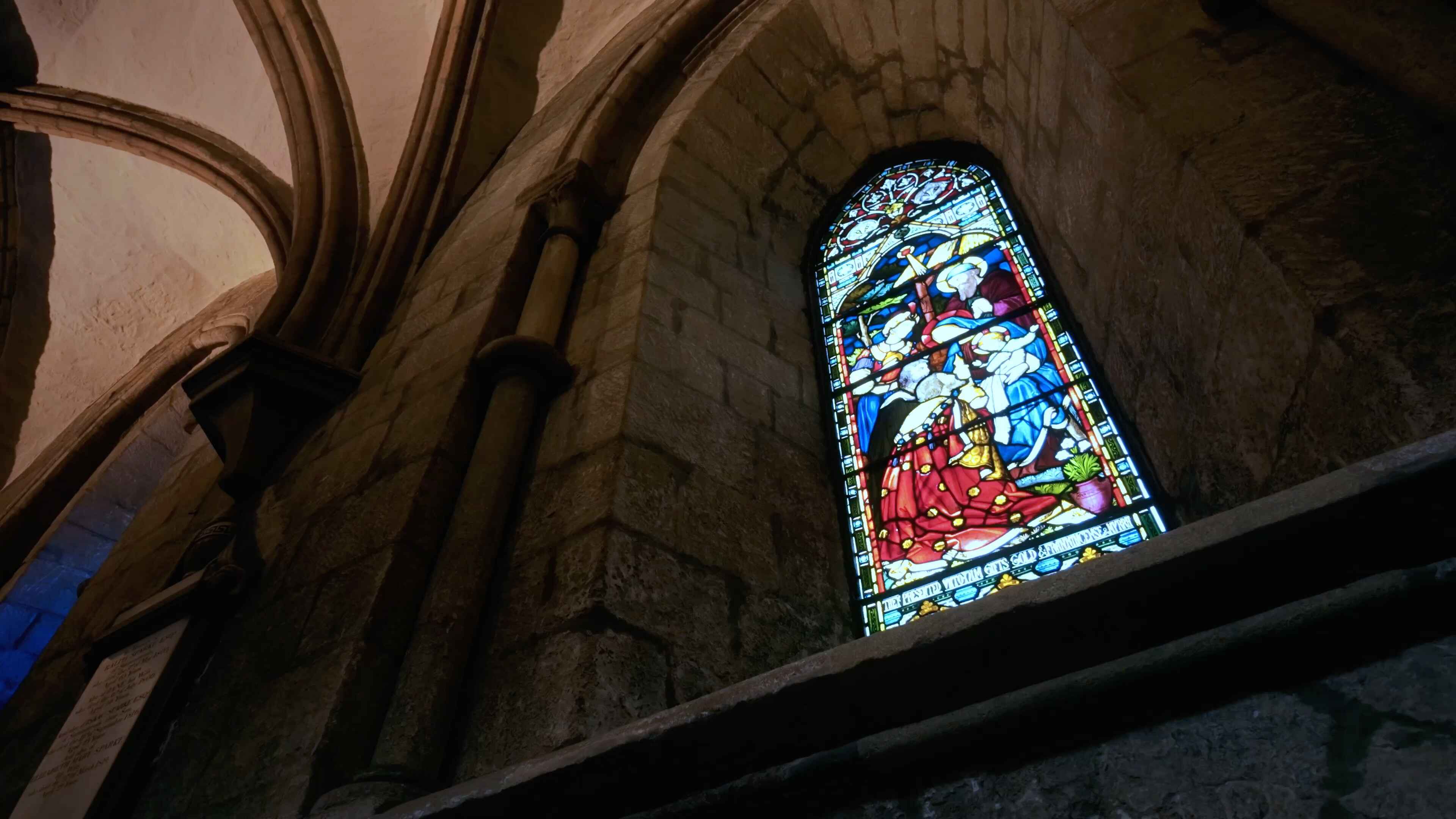 A stained glass window in an archway of an abbey