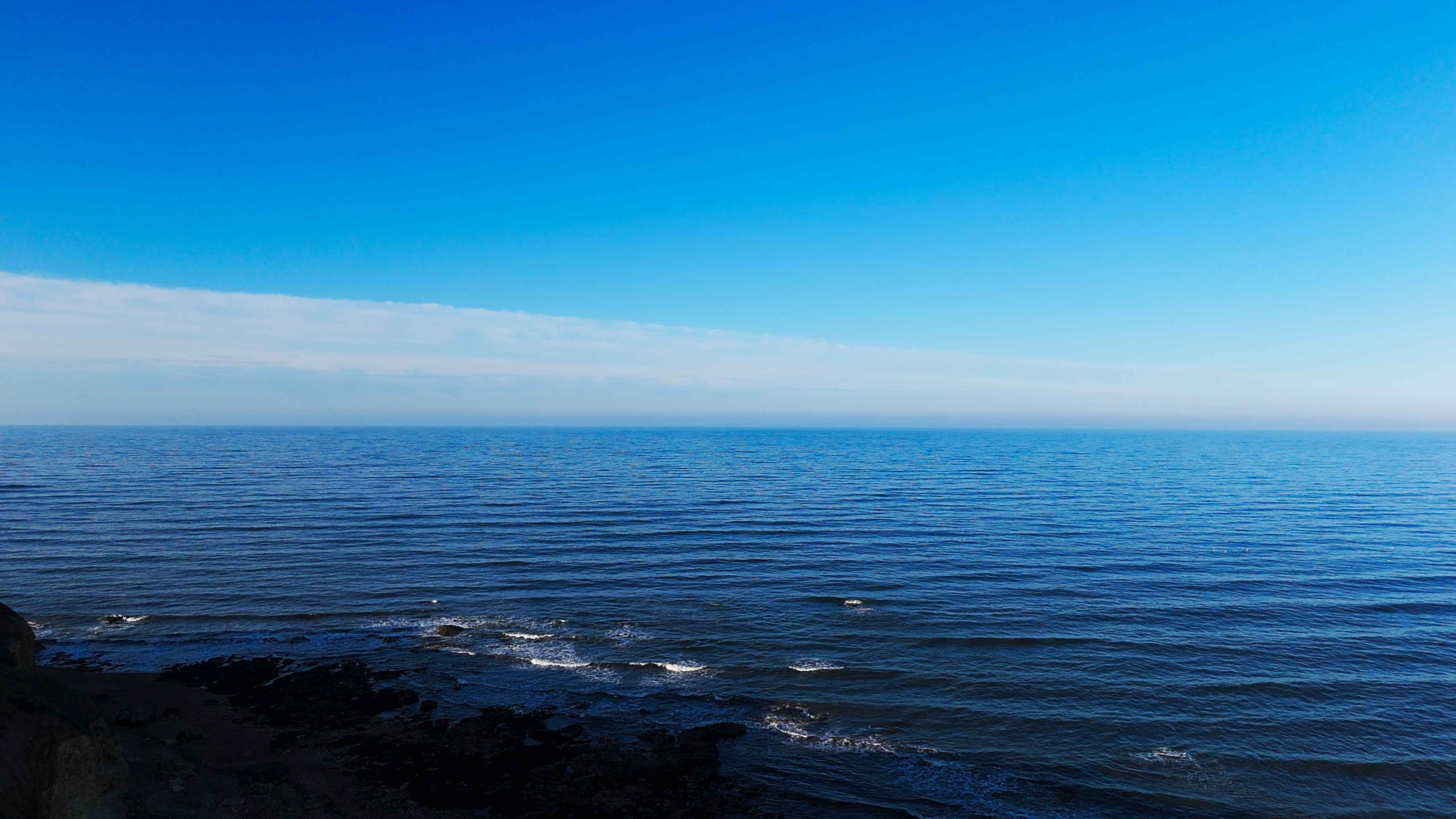 Striking blue water on a beachfront reaching out to the horizon
