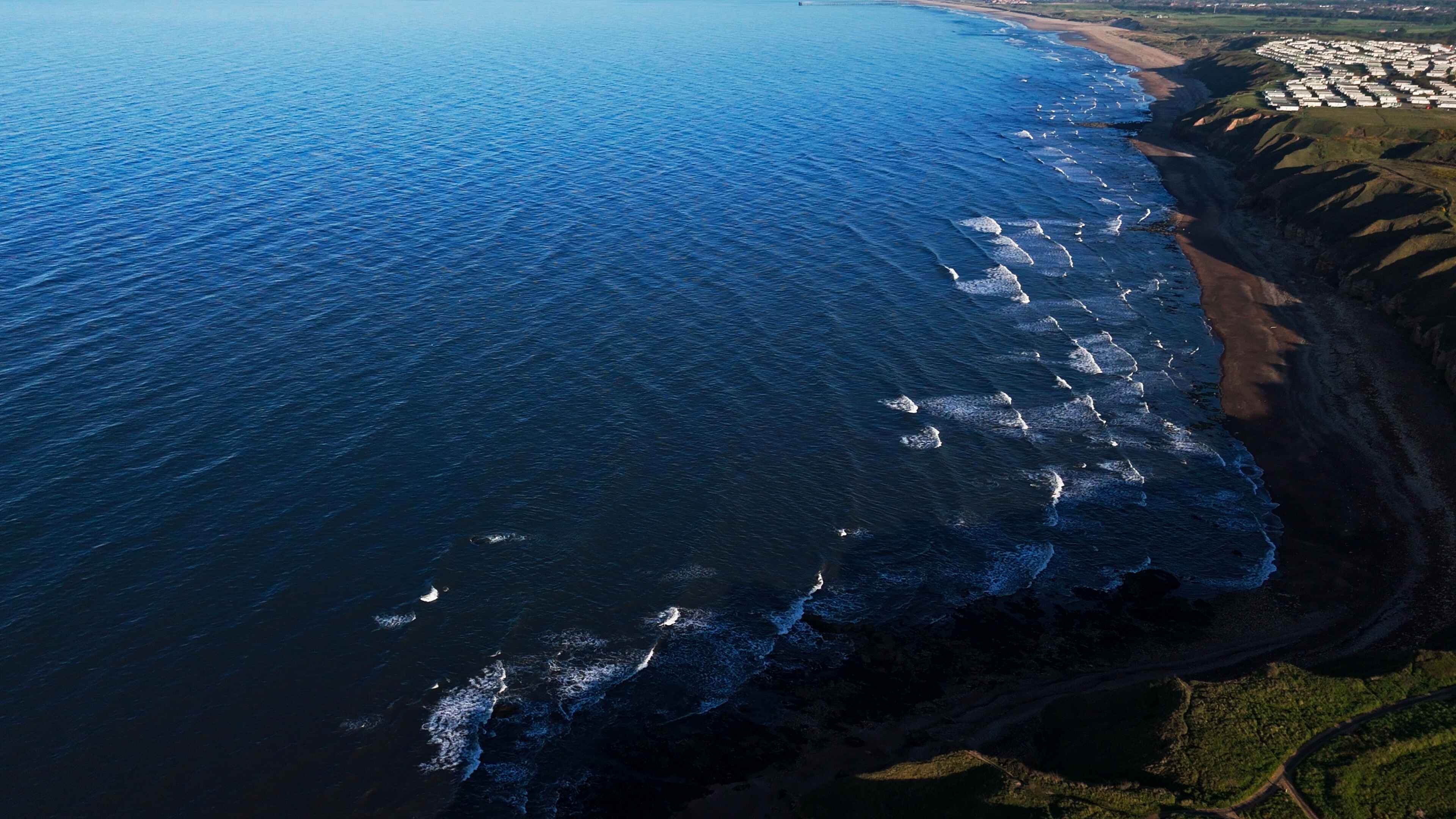 A large body of open water spread across the left of a beachfront