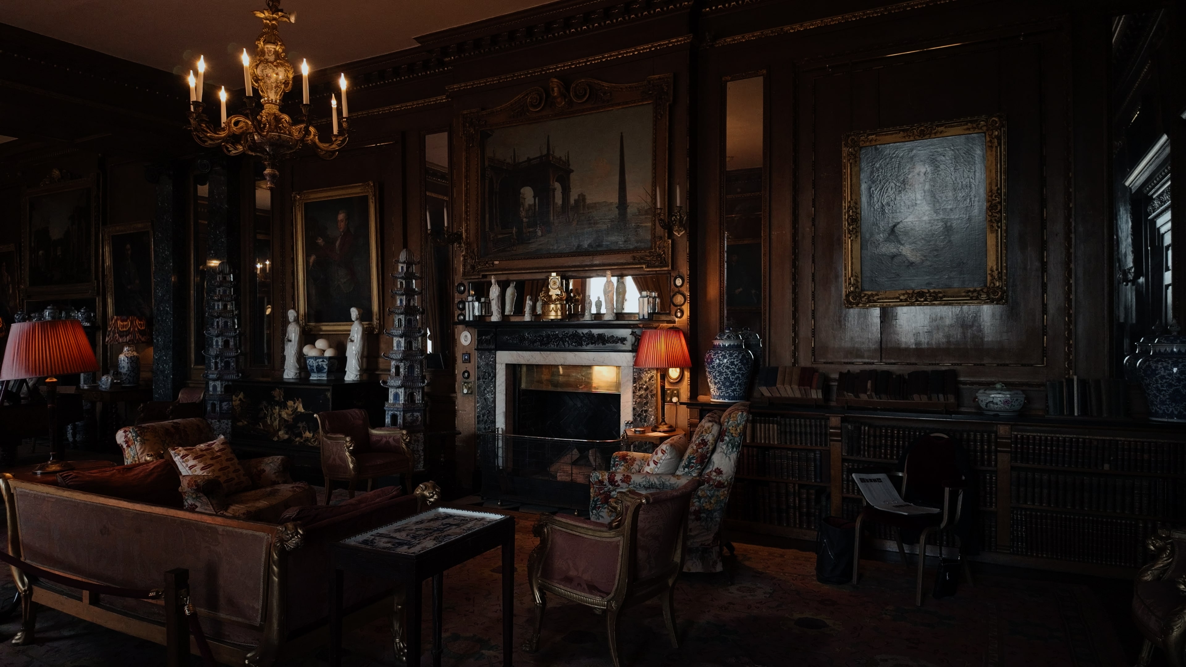 An estate room filled with furnishings, a marble fireplace and a chandelier