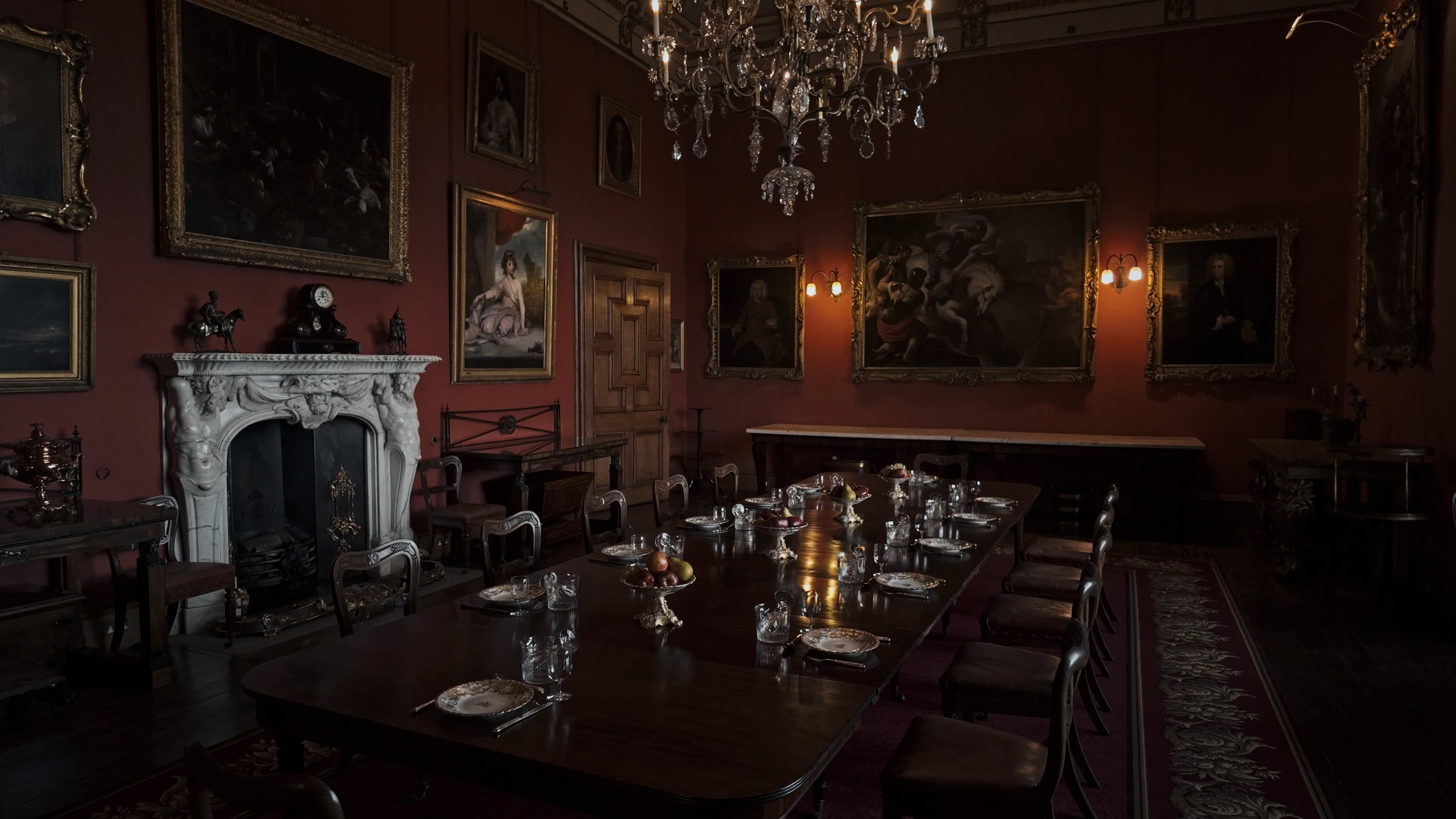 A large dining room with a long table, chairs, paintings and a chandelier at the center
