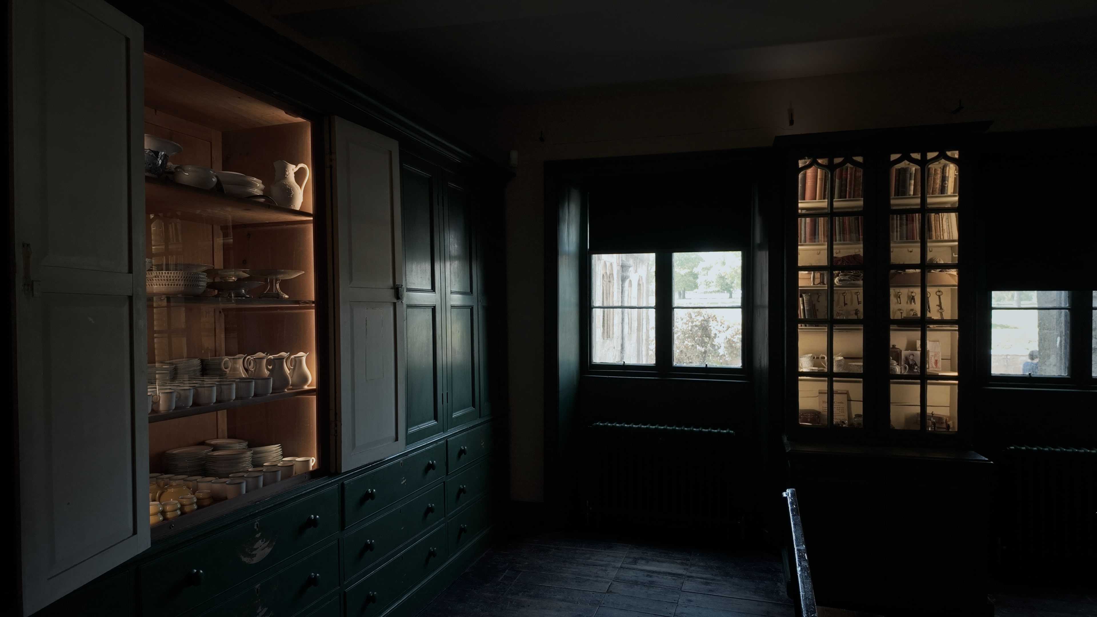 A large room with cabinets holding various books, crockery and keys