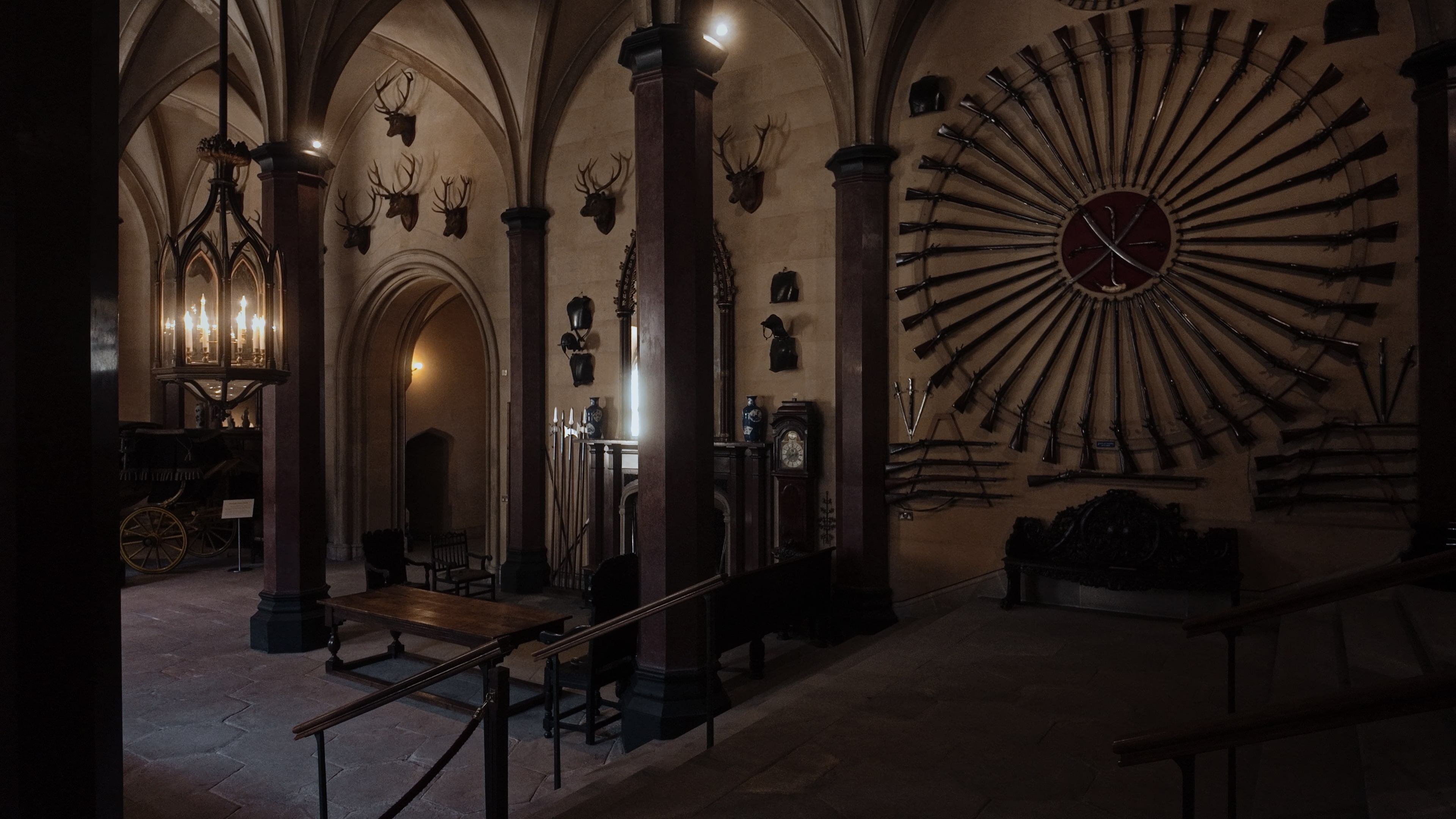 A large room with various wall-mounted armaments and stuffed animal heads