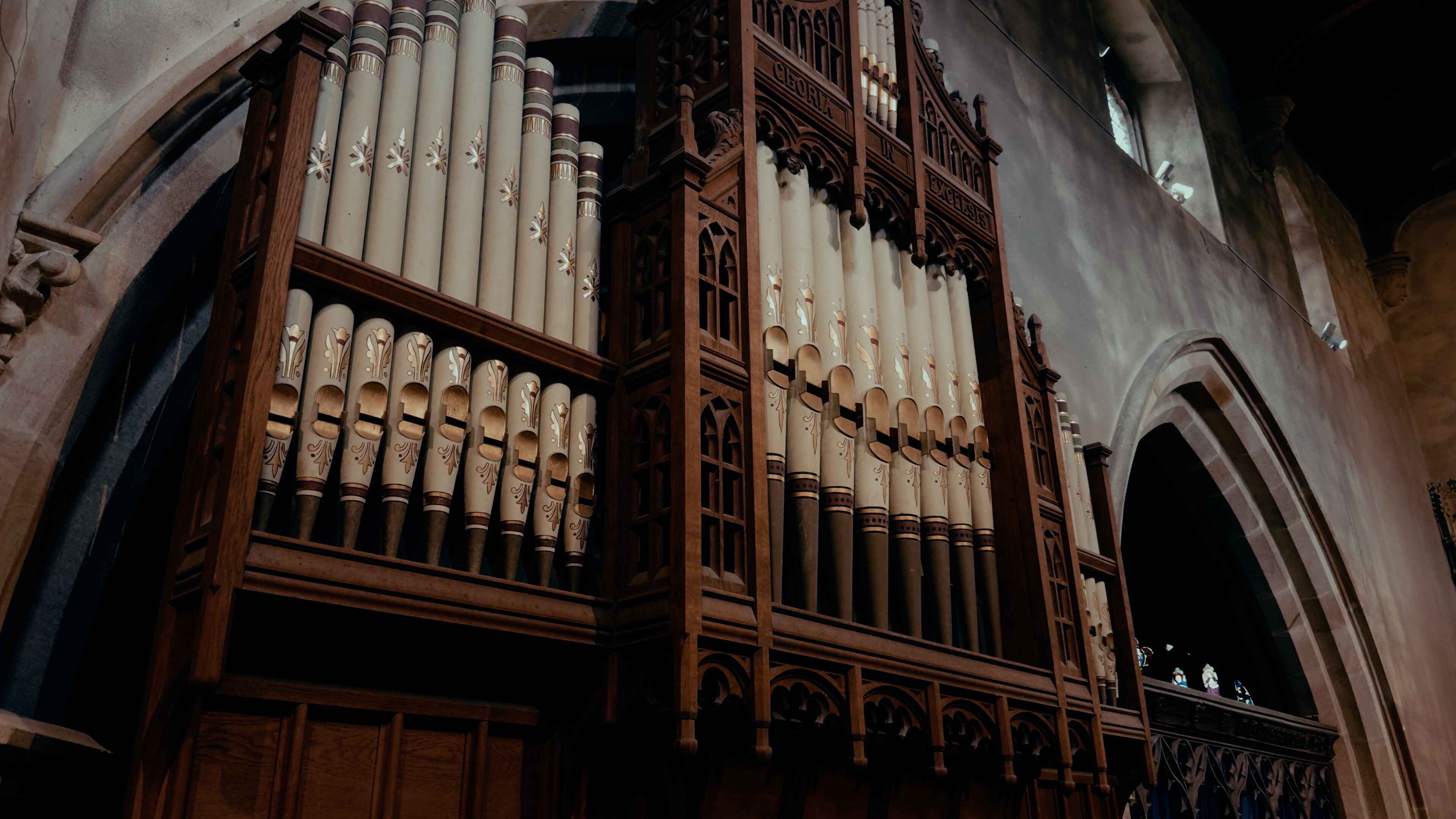 White church organ pipes encased in a wooden, engraved structure