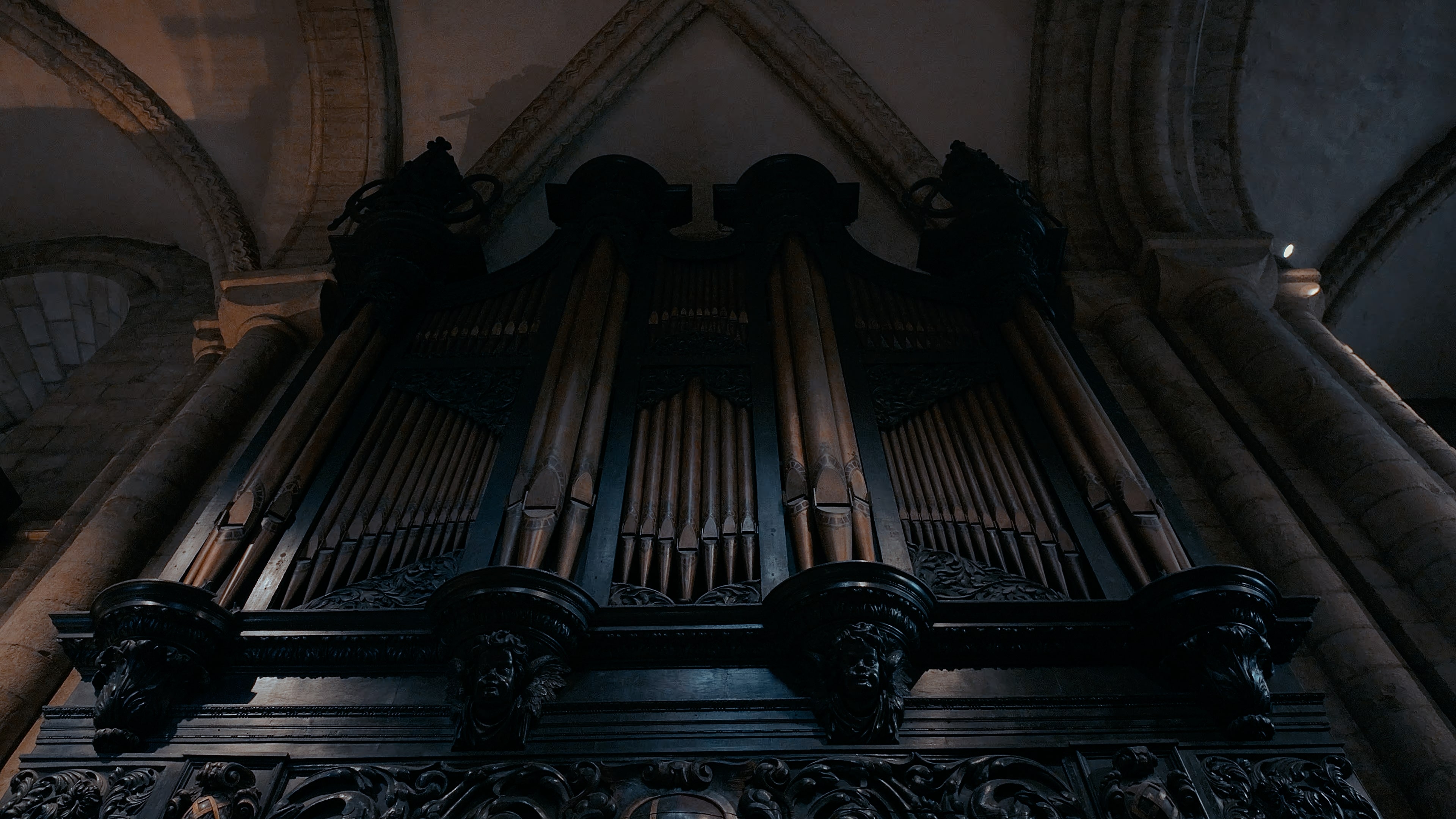 Three sets of organ pipes in a black engraved structure