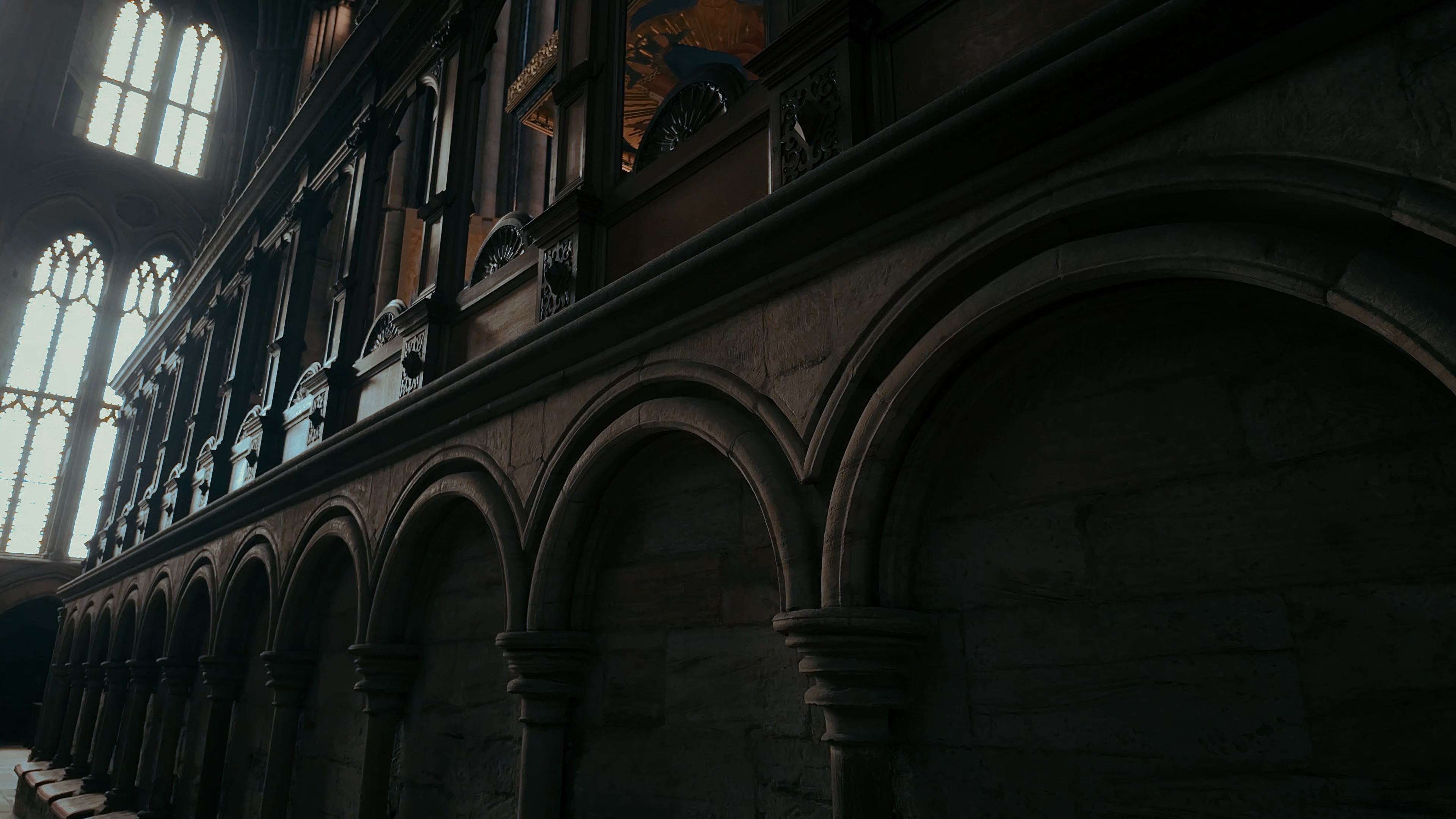 Curved engravings along the walls of a mezzanine with light in the back left