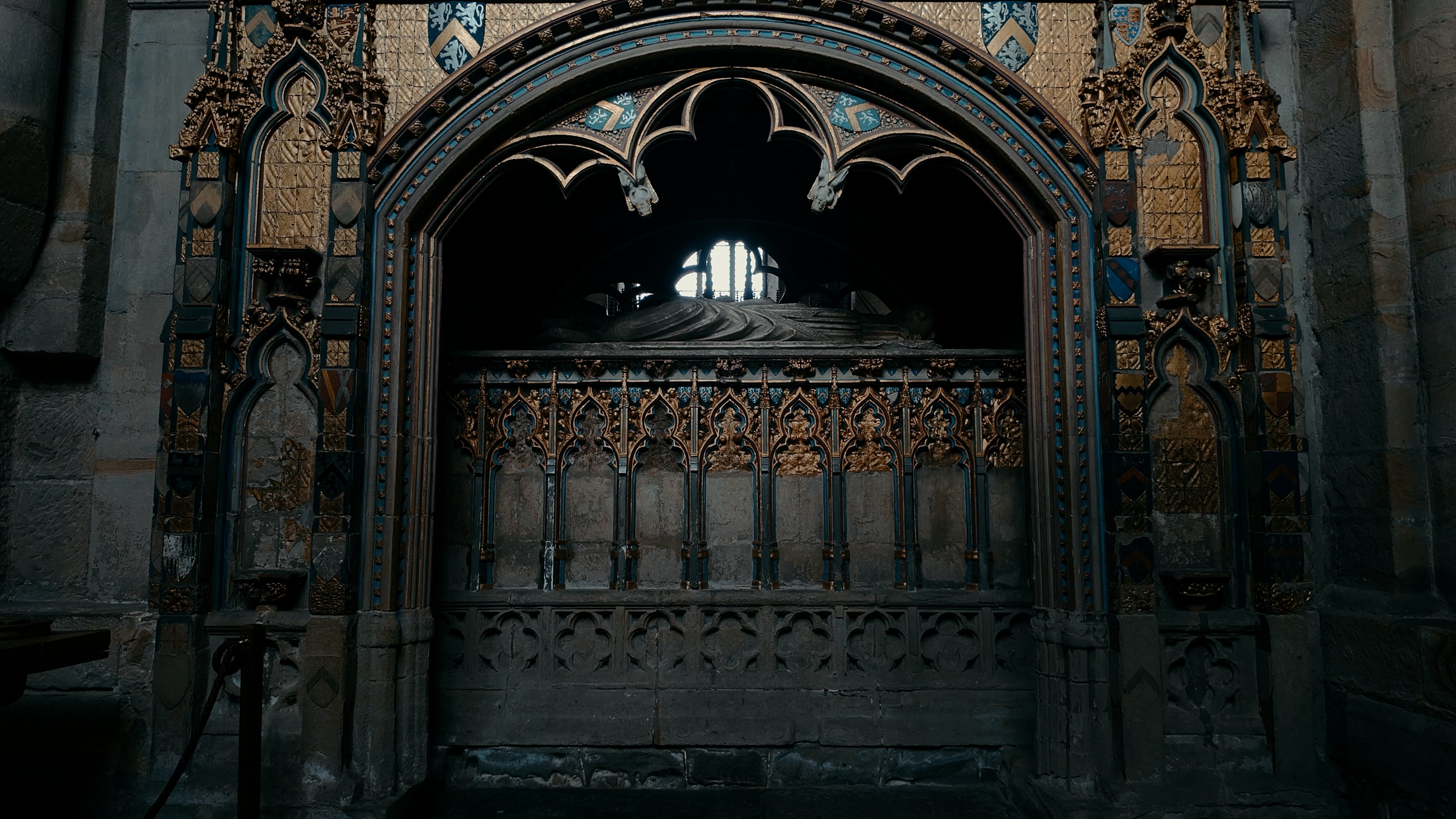 A tomb underneath an archway adorned with golden engravings and insignias