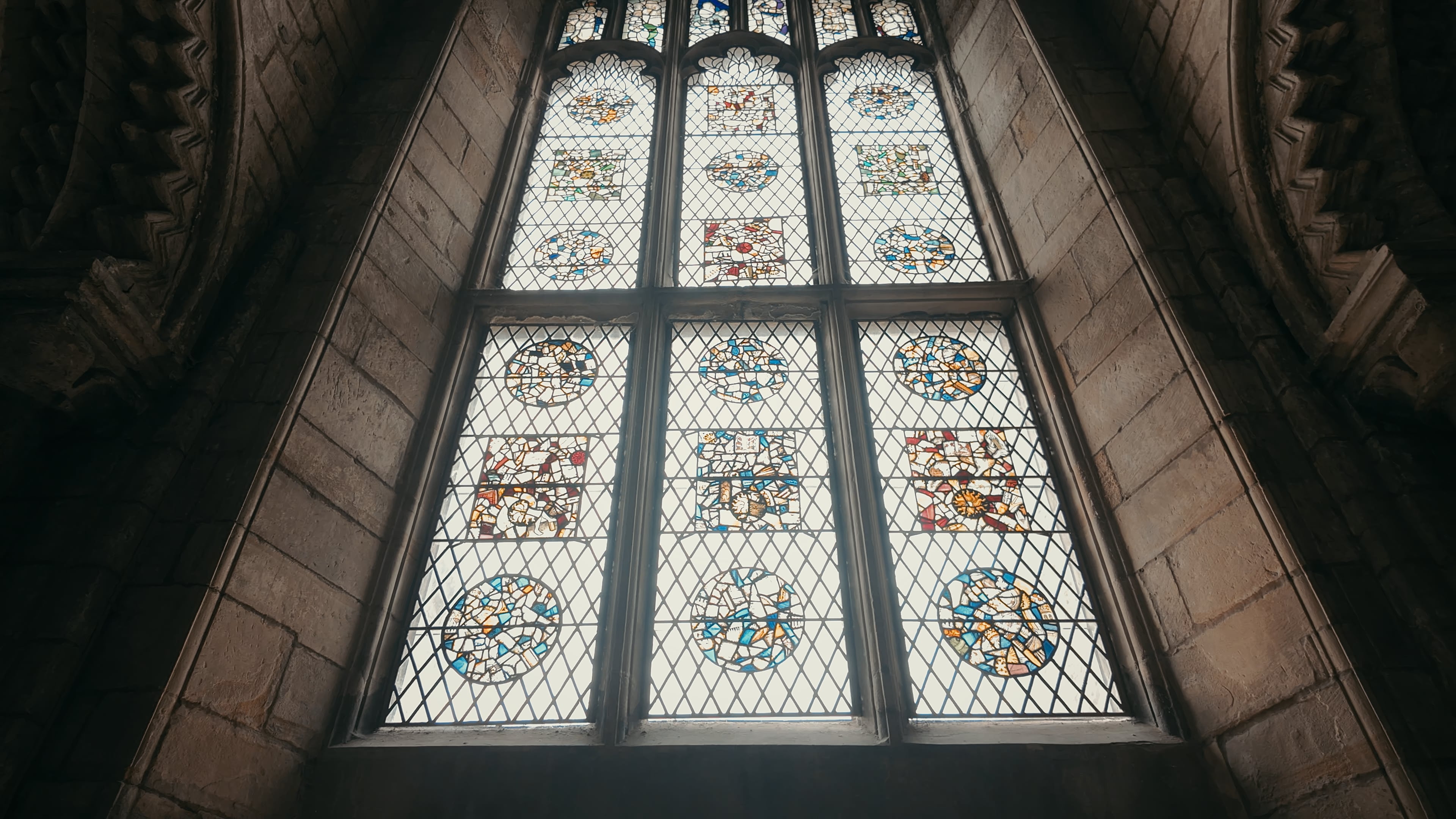 A large stained glass window from the viewpoint of looking upwards