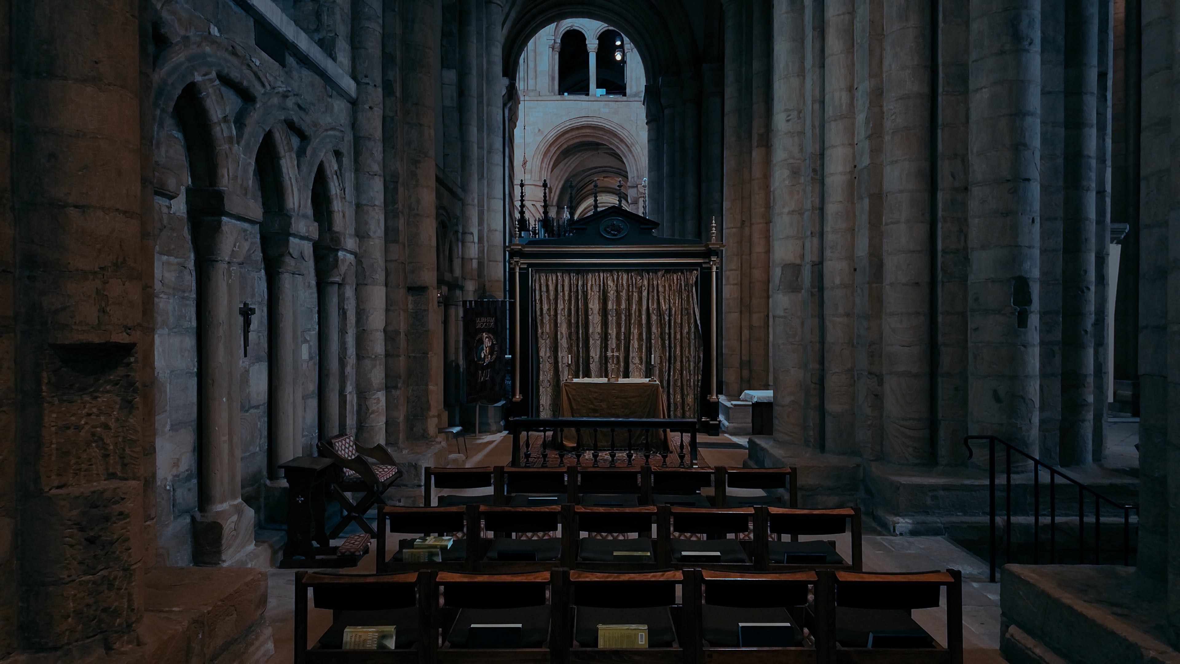 A series of chairs in front of a cathedral shine and the cross of Jesus